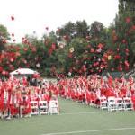 Ballard High School Grads throw caps during graduation ceremony.